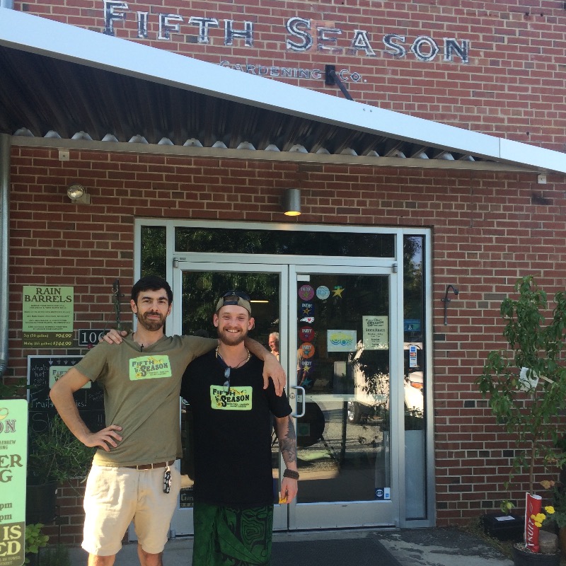 Owner and another employee of Fifth Season standing in front of the door to the store
