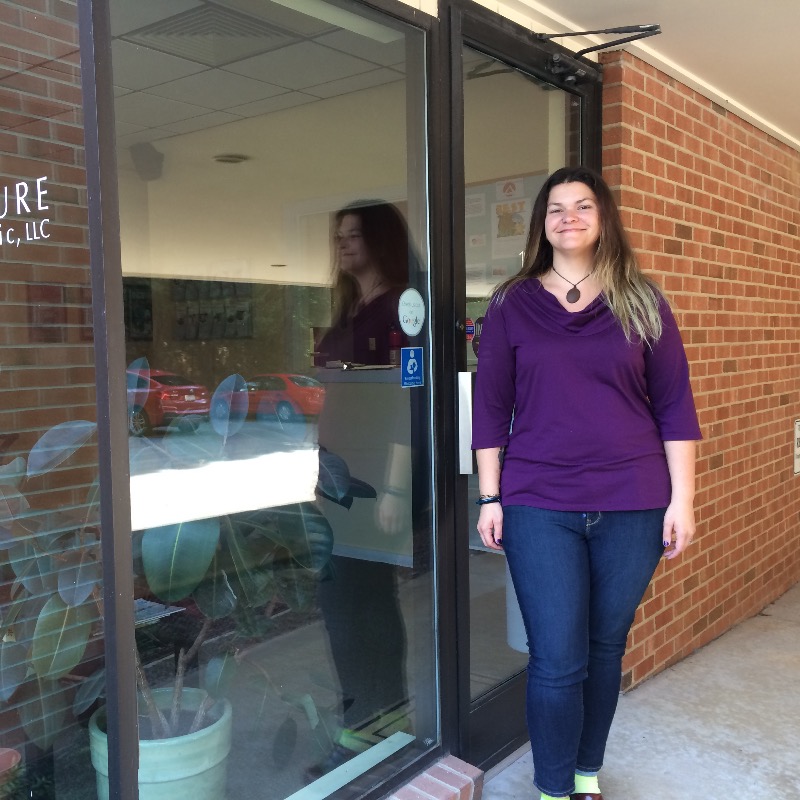 Triangle Acupuncture Clinic employee standing in front of office door