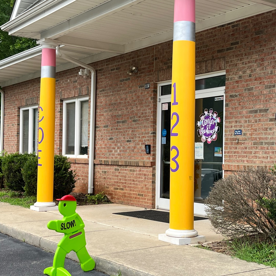 Center of Excellence Child Care and Academy front door and two columns